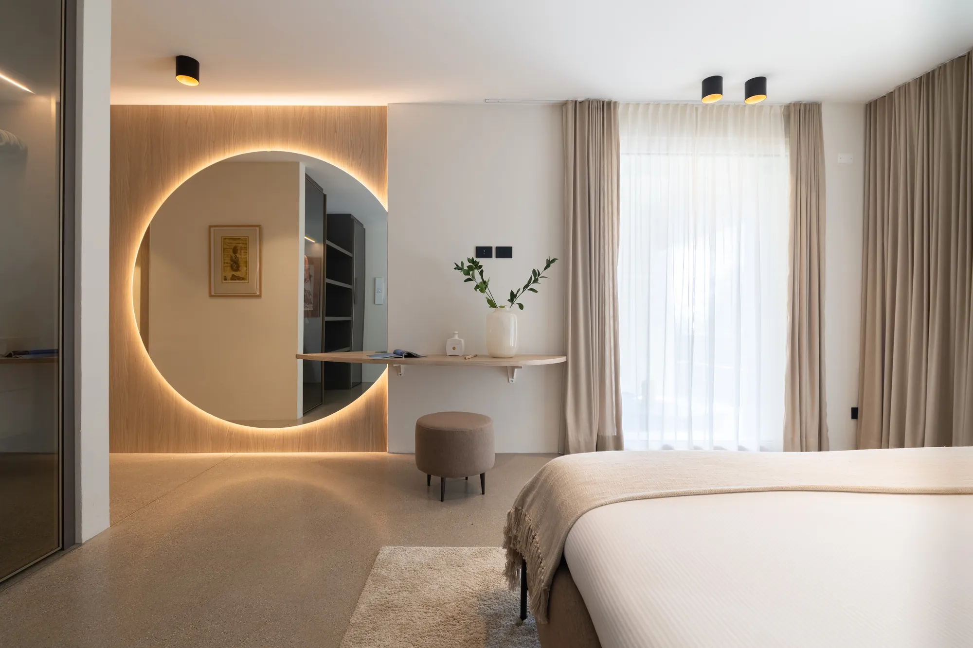 Double bedroom with backlit round mirror and dressing table