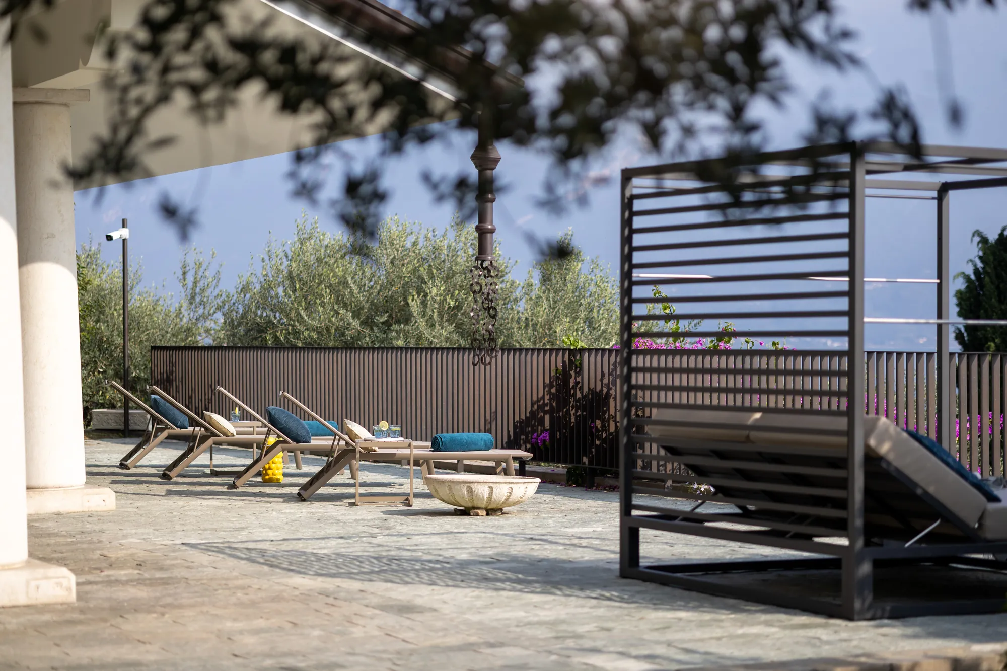 Terrace with sun loungers and a pergola daybed among the olive trees