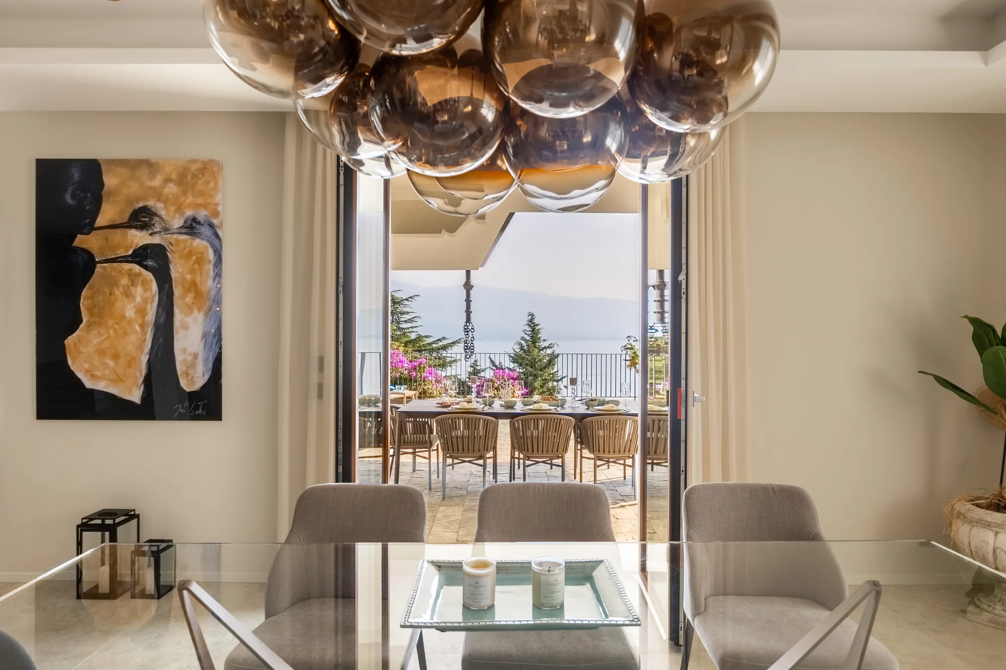 Dining room opening onto the covered terrace with views of Lake Garda