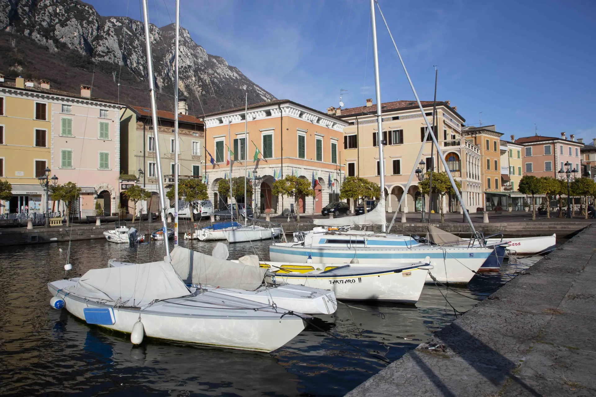Sailing boats in the small harbor of Gargnano, framed by pastel palazzi
