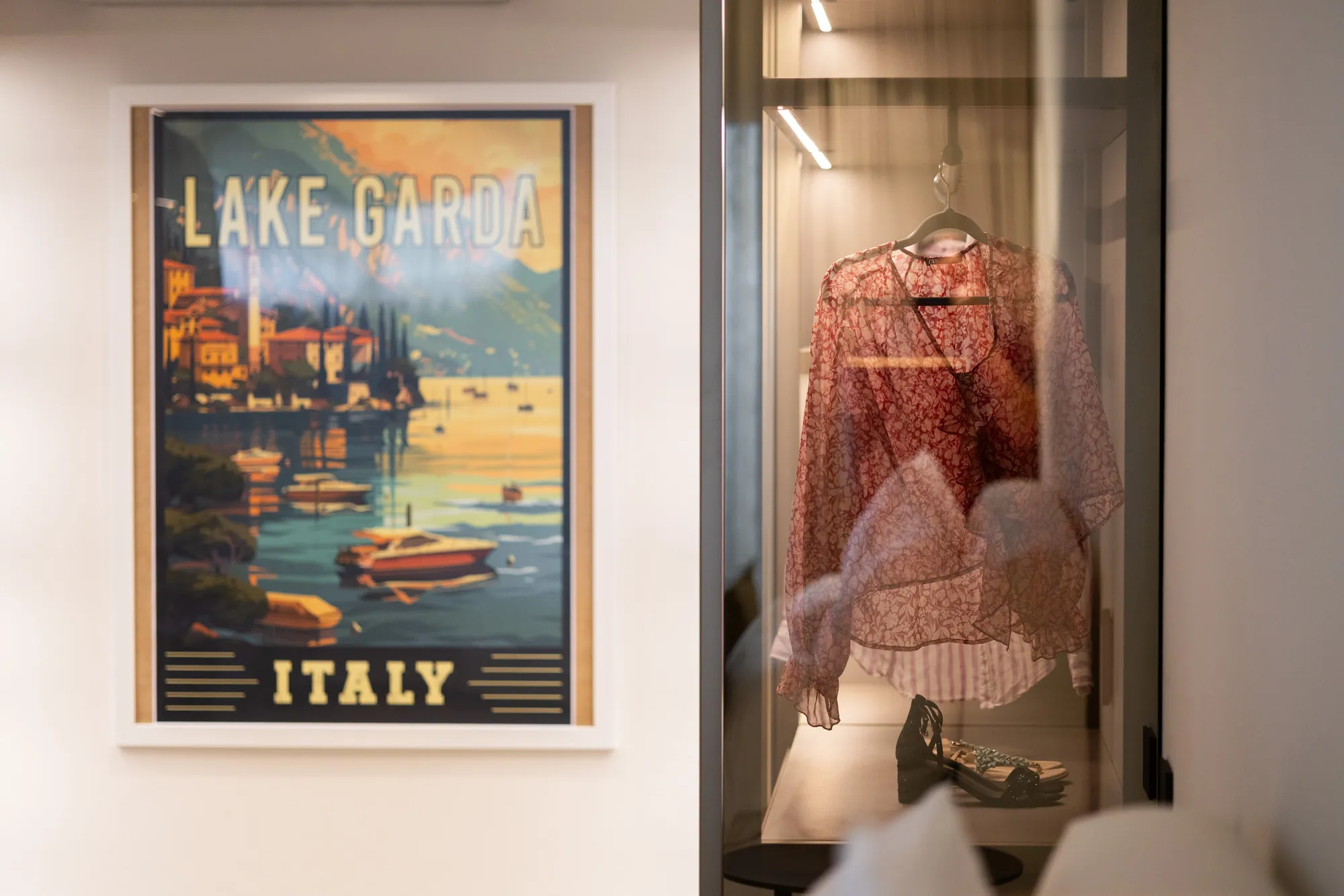 Vintage Lake Garda travel poster beside a glass wardrobe