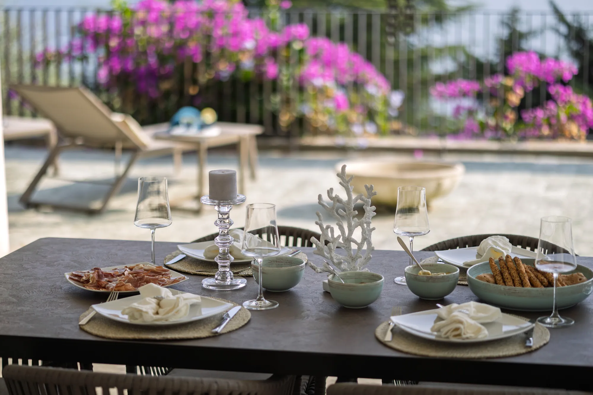 Al fresco lunch with antipasti and wine glasses on the bougainvillea terrace