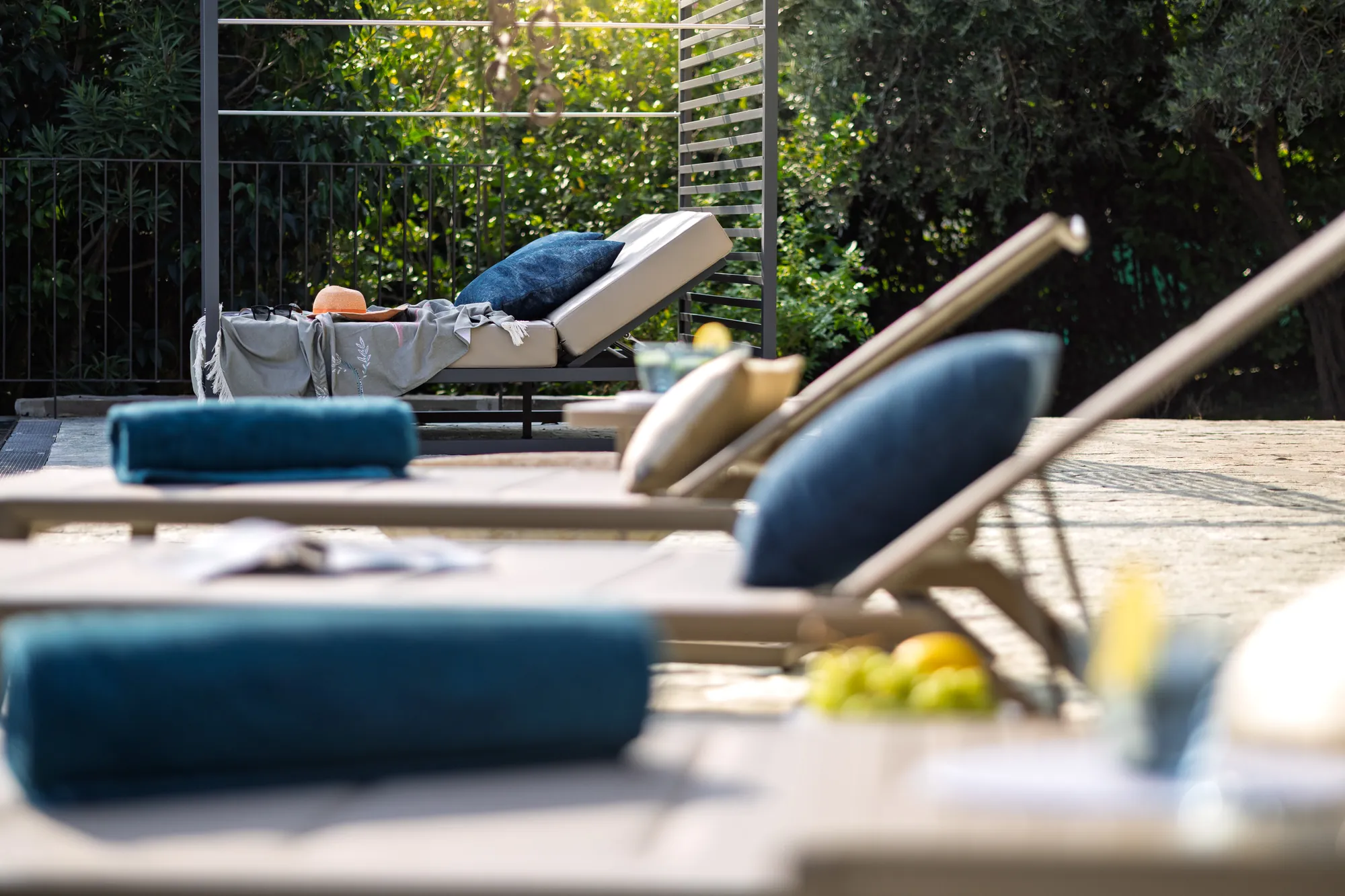 Sun loungers with blue cushions and rolled towels