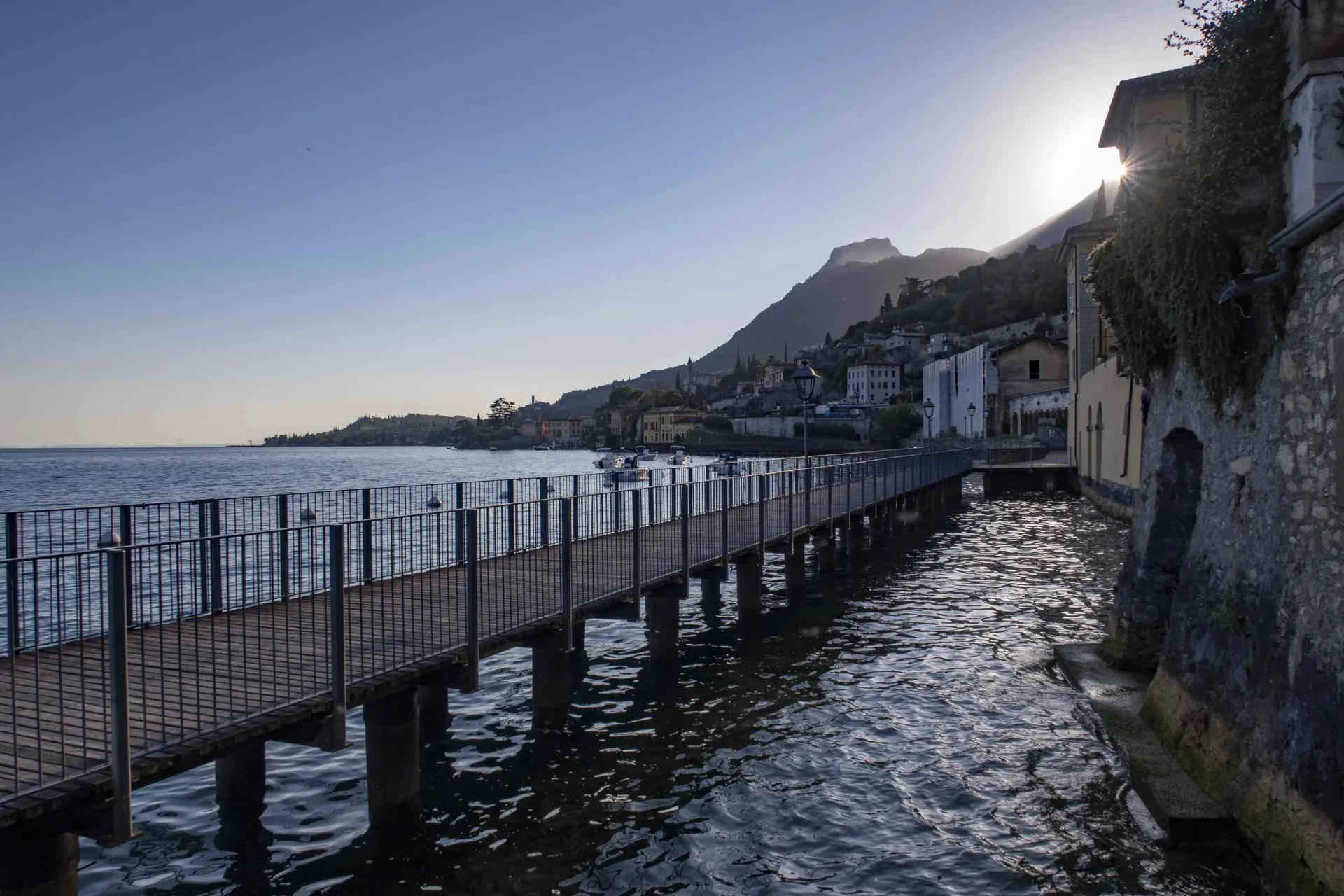 Wooden walkway over the water along the old houses of Gargnano