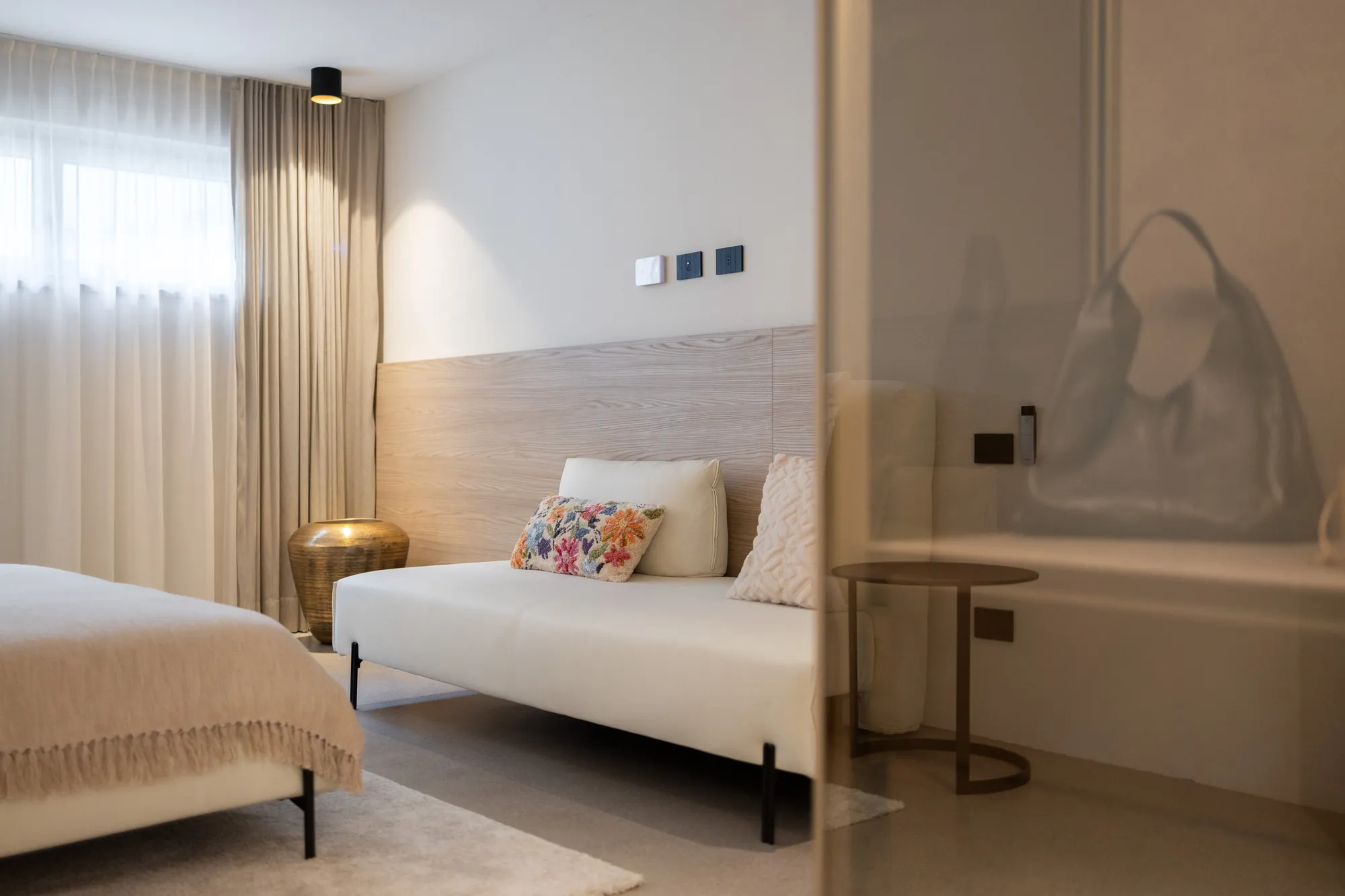 Bedroom seating area with white daybed and embroidered cushions