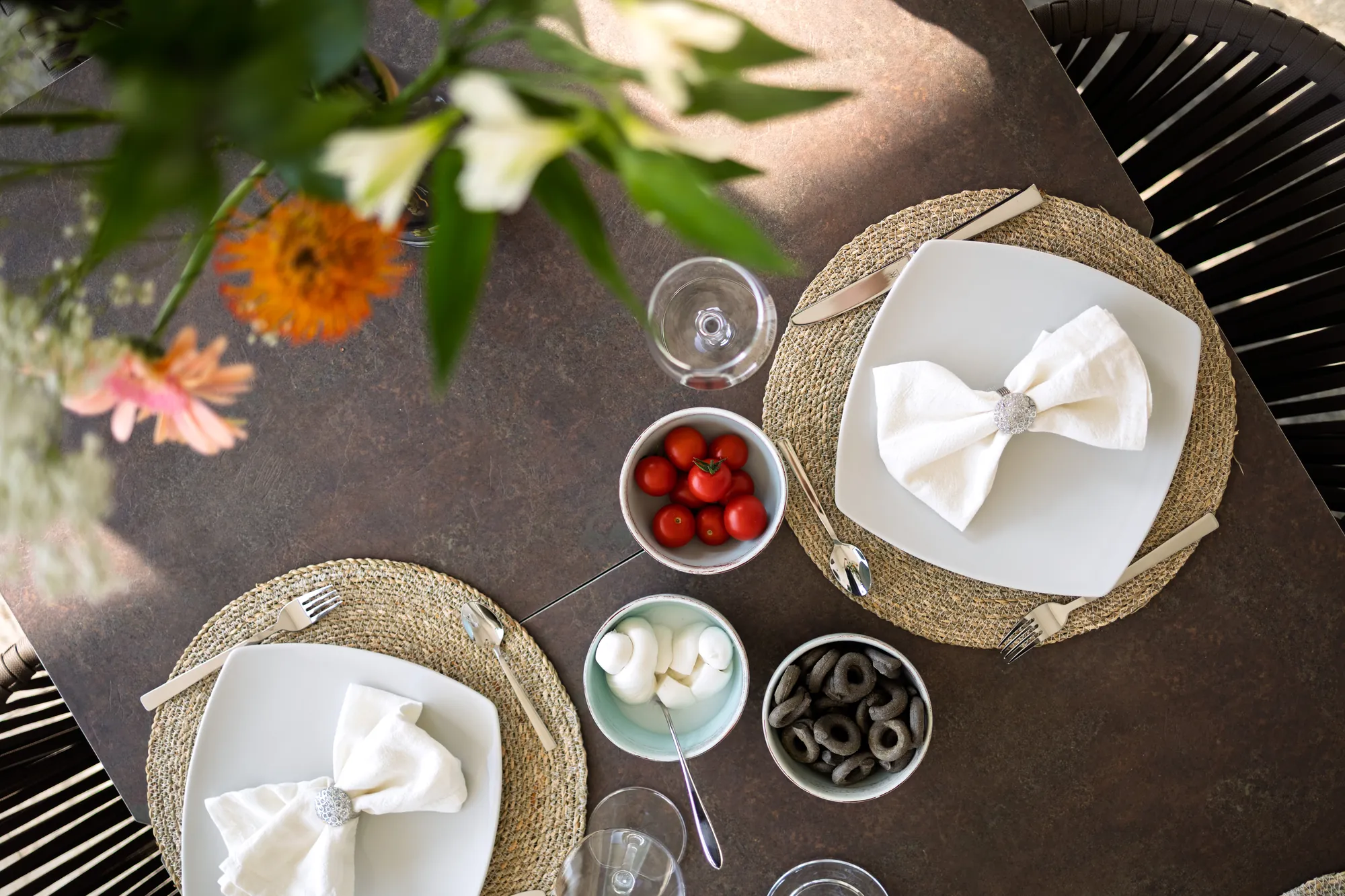 Table set for two with cherry tomatoes and mozzarella, seen from above