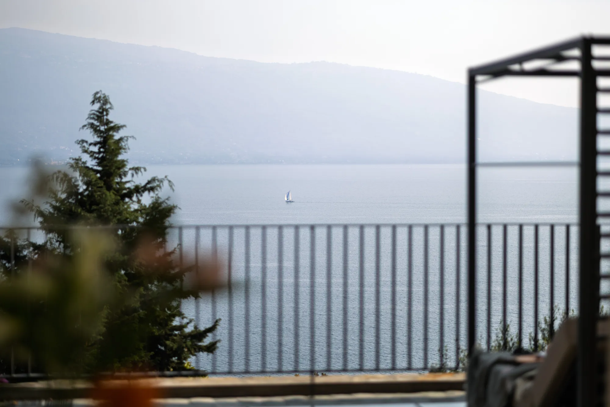 Lake Garda with a lone sailboat, seen from the villa's terrace